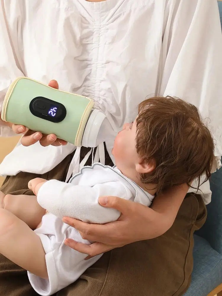 Person holding a baby and a green electronic device with a screen.