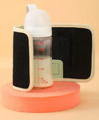 Bottle with black brush and white cap on a peach-colored platform